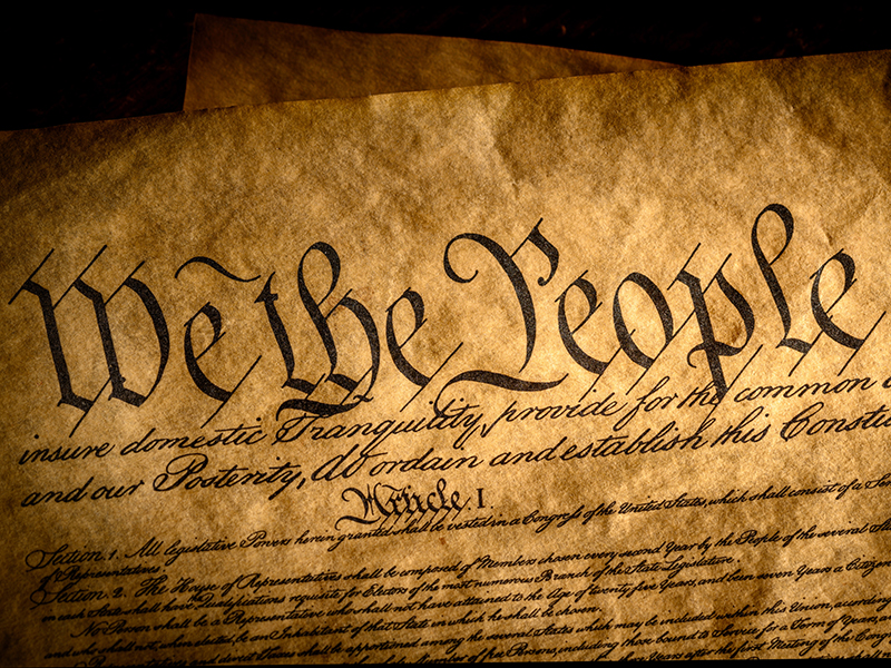 We the People, the beginning of the United States constitution lit by a window light