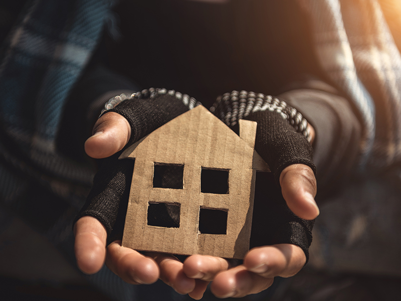 person holding a cardboard cut out of a house